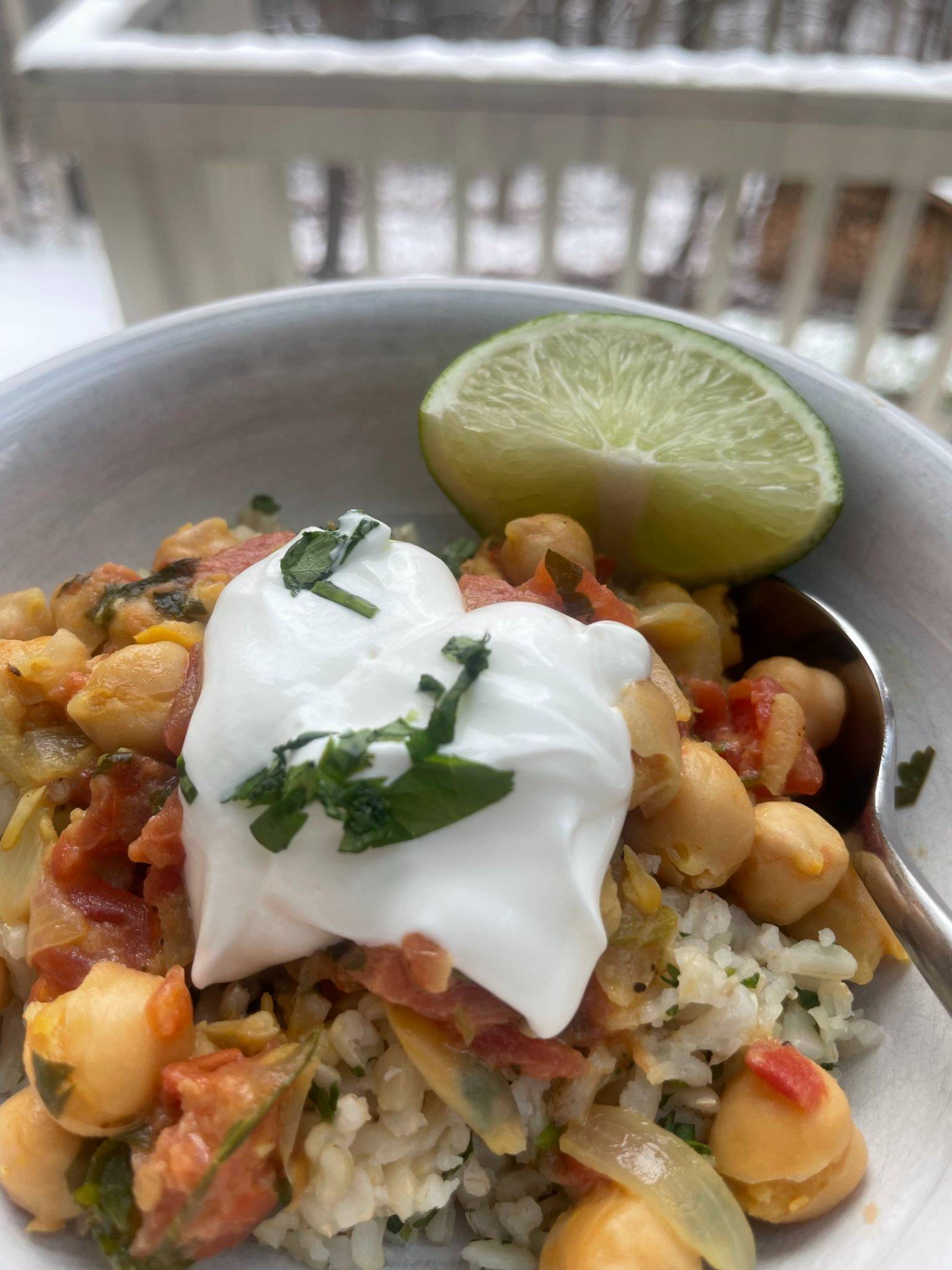 Bowl of chickpea curry with lime for garnish